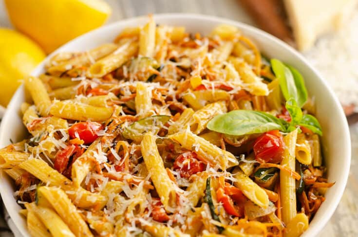 Pasta Primavera in white bowl with fresh basil, lemon and parmesan